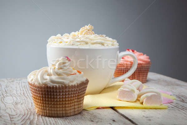 hot chocolate with marshmallows, cream and cupcakes on wooden ba Stock photo © artjazz