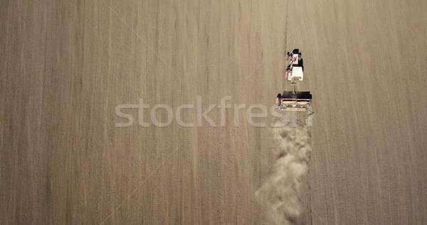 Aerial view the tractor is working in the field creating dust clouds. Spring work in the field. Phot Stock photo © artjazz