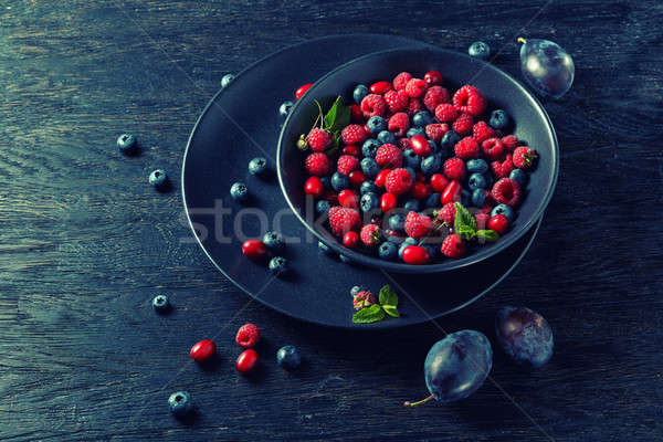 raspberries, blueberries, plum and dogwood. fresh berries on plate Stock photo © artjazz