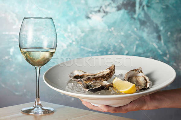 Oysters in a white plate with lemon Stock photo © artjazz