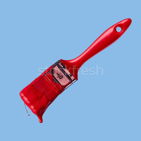 Stock photo: red paintbrush isolated on a blue background