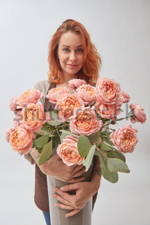 Stock photo: Sexy red-haired woman is sniffing roses media