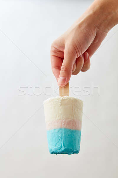 Ice lolly. A girl's hand holds a homemade sweet ice cream on a gray background with copy space. Summ Stock photo © artjazz