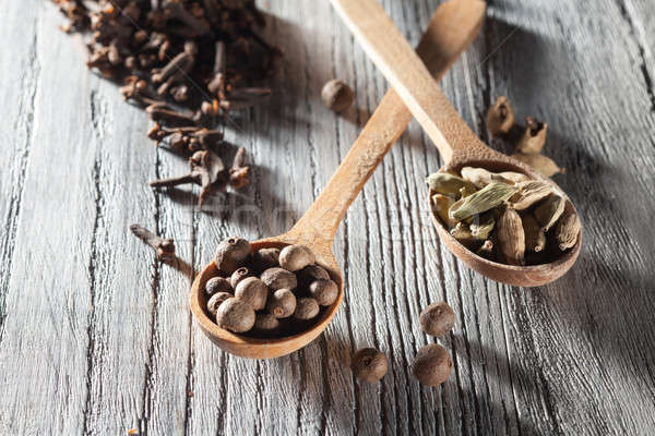 Nutmeg, clove and allspice in old spoon on wooden table Stock photo © artjazz