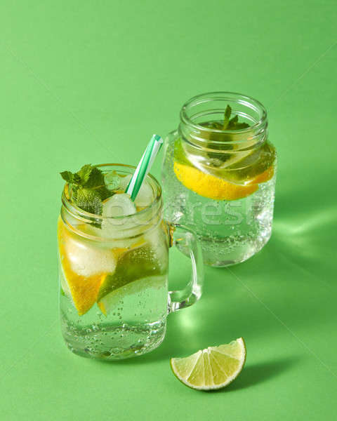 Summer refreshing cocktail from natural citrus fruits with ice, water, mint and plastic straw in the Stock photo © artjazz
