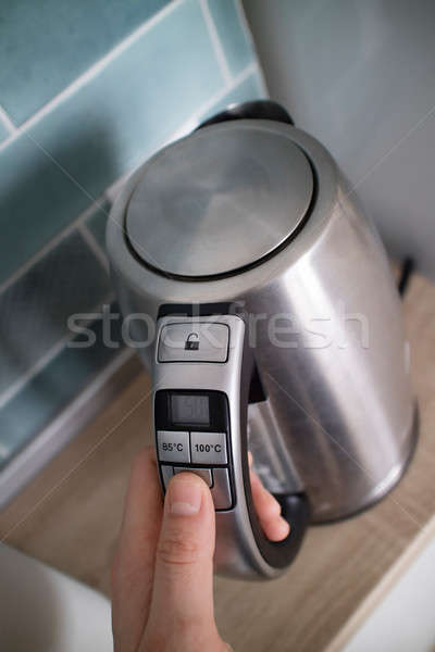metal kettle in the kitchen in the man hand on a kitchen Stock photo © artjazz