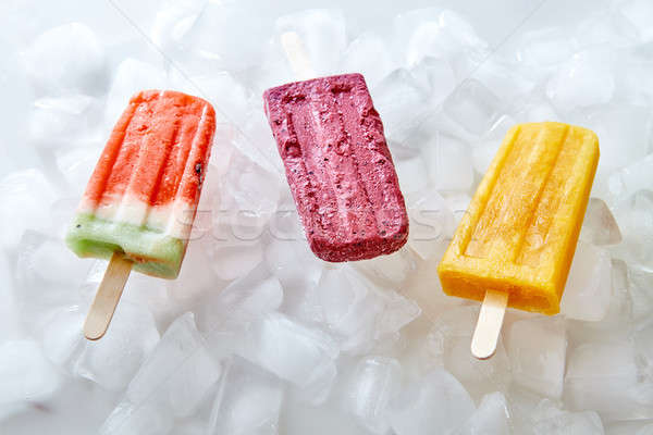 Watermelon, berry, peach, homemade ice lolly on ice cubes. Sweet cold dessert. Flat lay Stock photo © artjazz