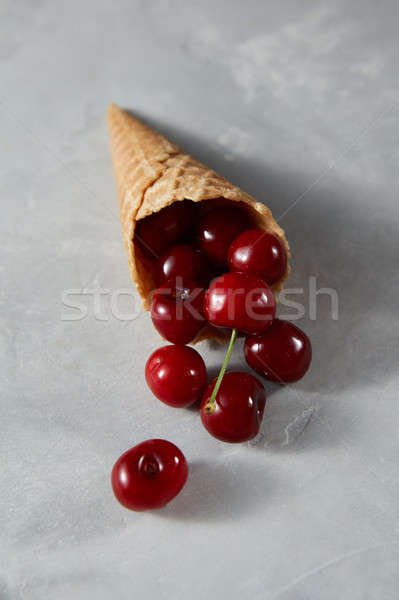 Summer fruits ripe red cherries in a wafer cones on a gray stone Stock photo © artjazz