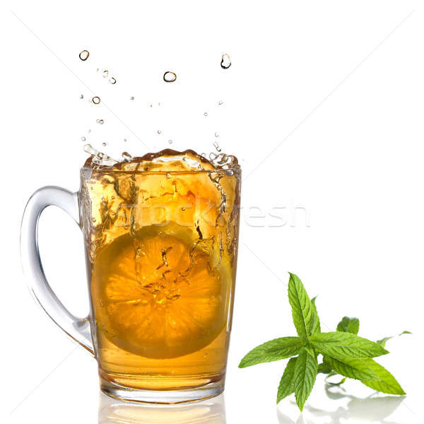 lemon dropped into tea cup with splash and mint isolated on white Stock photo © artjazz