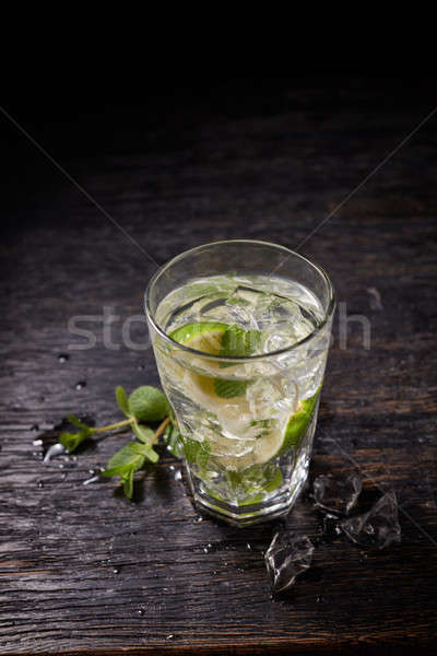 From above shot of mojito cocktail with ice and mint in glass on dark background Stock photo © artjazz