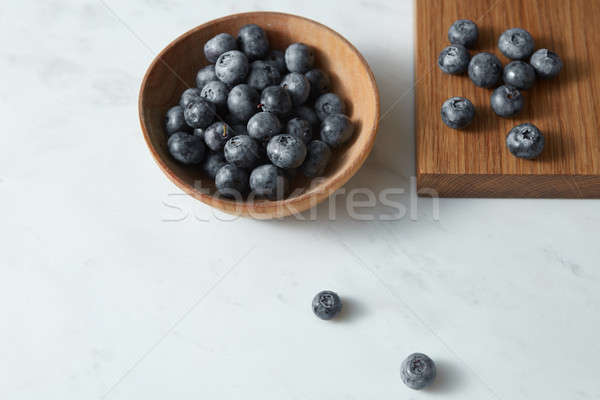 Summer organic natural sweet blueberries in a wooden plate on a white. Copy space. Stock photo © artjazz