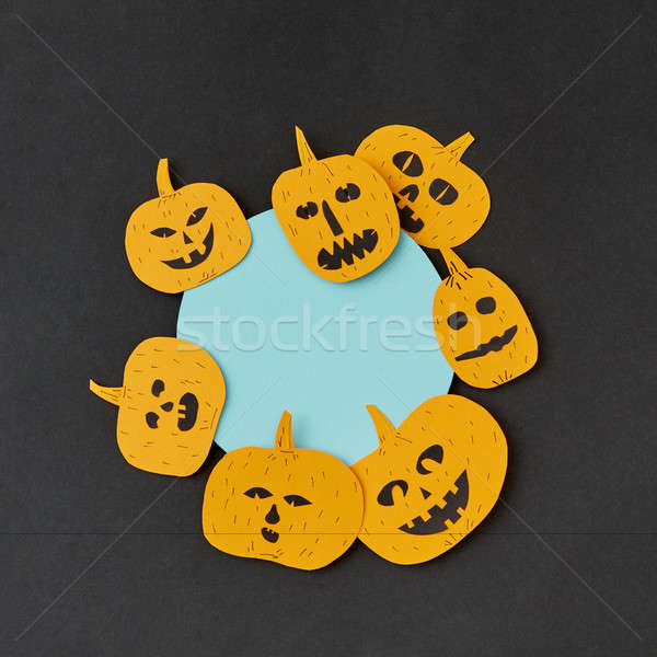 Decorative round blue Halloween frame handcraft with paper laughing pumpkin on a black paper backgro Stock photo © artjazz