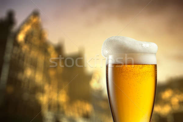 Glass of beer against blurred european city Stock photo © artjazz