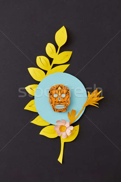 Colorful modern Calaca composition from paper with yellow leaf and decorative skull on a black paper Stock photo © artjazz