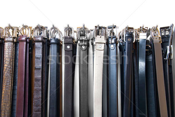 a lot of leather belts in store isolated on white Stock photo © artjazz