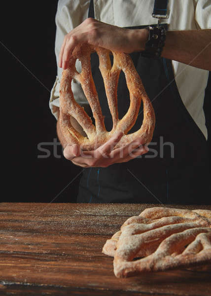 Baker's hands hold fougas bread Stock photo © artjazz