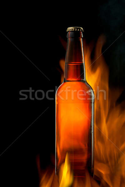 Beer bottle in fire on black Stock photo © artjazz