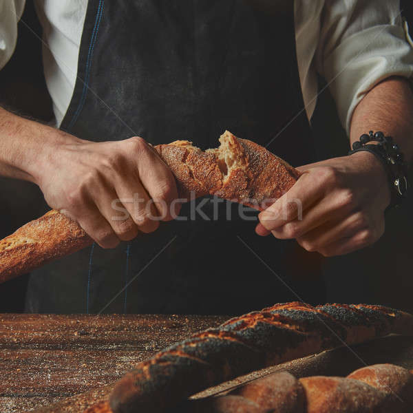 Mężczyzna ręce przerwie bagietka piekarz organiczny Zdjęcia stock © artjazz