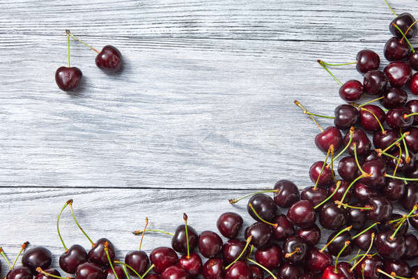 Berries frame from freshly picked cherry on wooden gray background with copy space. Stock photo © artjazz