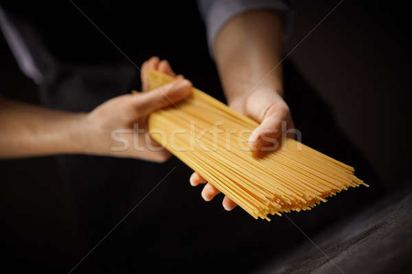 Femme Cook brut spaghettis sombre Photo stock © artjazz