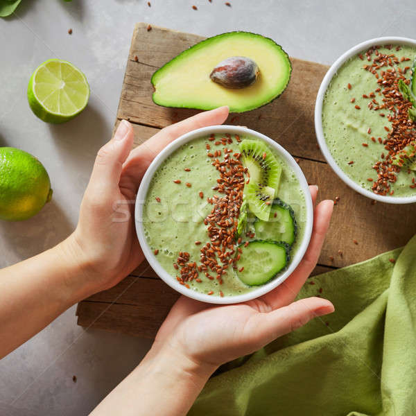 In the female hands of a bowl with green healthy smoothies Stock photo © artjazz