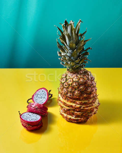 Tropical Pineapple fruit single whole and dragon fruit, pitaya made up of sliceson on a duotone yell Stock photo © artjazz