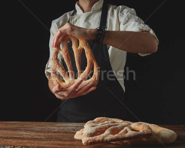on background of wooden brown table, men's hands hold bread foug Stock photo © artjazz