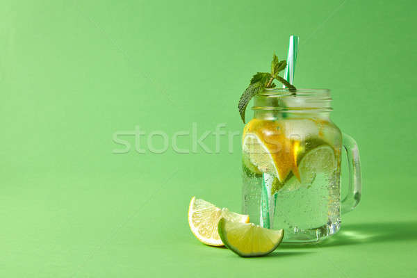 Mason jar with fresh homemade sparkling lemonade with citrus fru Stock photo © artjazz