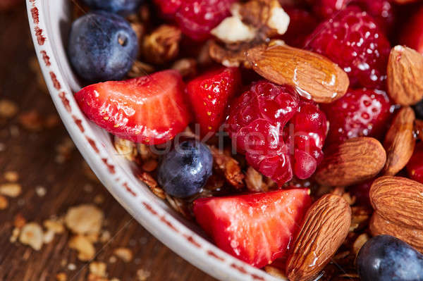 Fresh organic berries, almonds, granola, honey in a bowl - ingre Stock photo © artjazz