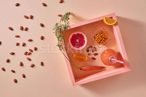 Organic vegetable smoothies with citrus fruits, almonds and sea-buckthorn in a bottle on a yellow pa Stock photo © artjazz