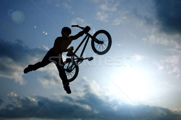Silueta nino bicicleta saltar aire puesta de sol Foto stock © artjazz