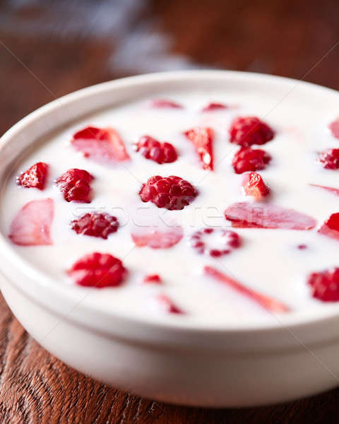 White bowl with helthy breakfast with fresh ripe berries and yoghurt on a wooden table. Stock photo © artjazz