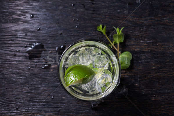 Mojito cocktail from top, vodka or soda drink with lime mint isolated on black wooden background Stock photo © artjazz