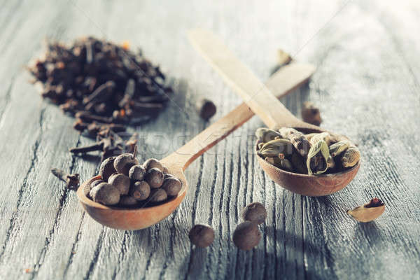 Nutmeg, clove and allspice in old spoon on wooden table Stock photo © artjazz