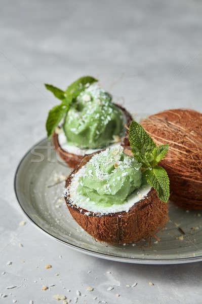 Fresh green mint ice cream in coconut shell with whole fresh coc Stock photo © artjazz