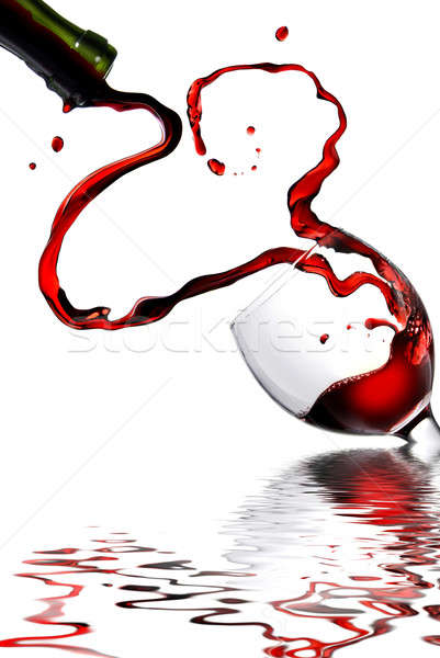 Heart from pouring red wine in goblet isolated on white Stock photo © artjazz
