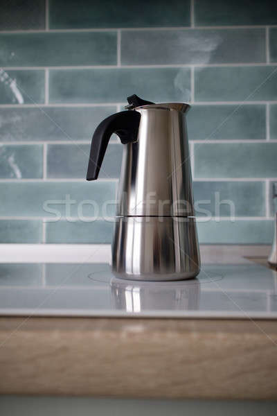 A stainless geyser coffee machine is on the electric stove. Stock photo © artjazz