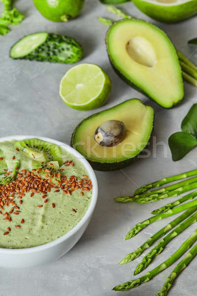 Green smoothie bowl on a light grey slate concrete background. Stock photo © artjazz