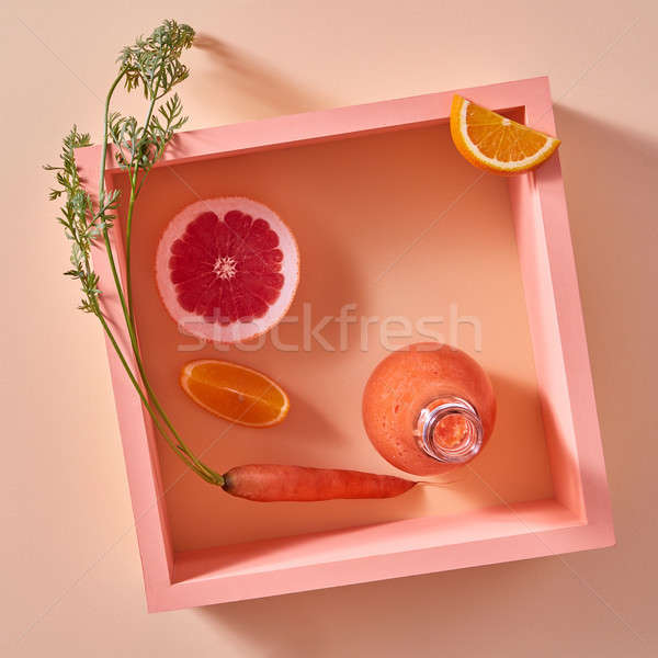 Orange detox smoothies from vegetables and fruits in a glass bottle on a yellow paper background. Stock photo © artjazz