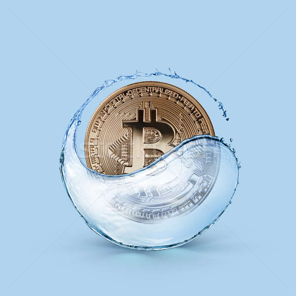 Gold coin bitcoin in a splash of water on a blue background Stock photo © artjazz