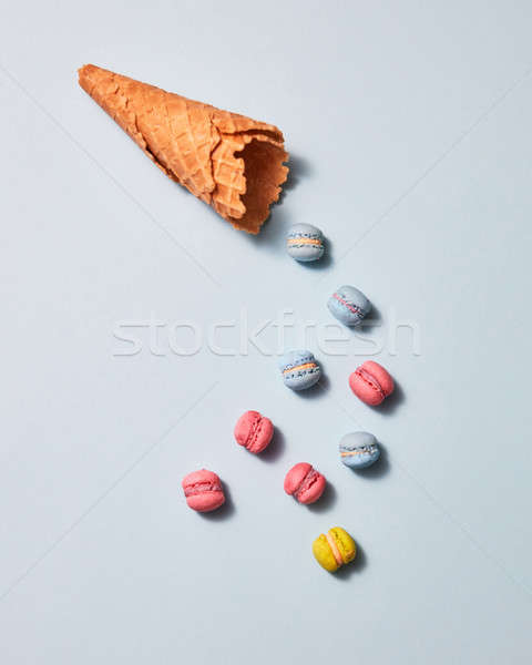 Multicolored macaroons and waffle cone presented on a gray background. Flat lay Stock photo © artjazz