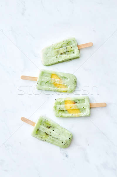 A set of delicious homemade berry ice cream lolly with a slice of mango on a gray marble table with  Stock photo © artjazz