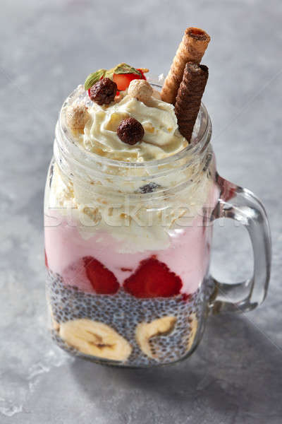 Fresh summer cocktail with banana, chia seeds and strawberry yogurt in mason jar on stone background Stock photo © artjazz