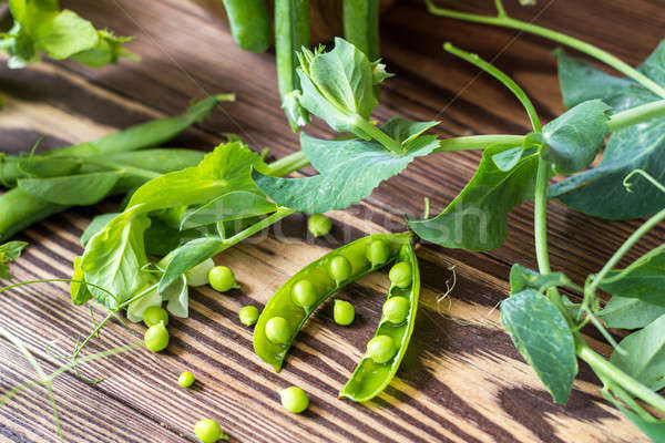 Stock photo: Pods of green peas and pea on a dark wooden surface. Vintage woo