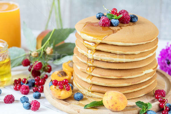 Fresh delicious pancakes with summer berries on light background Stock photo © artsvitlyna