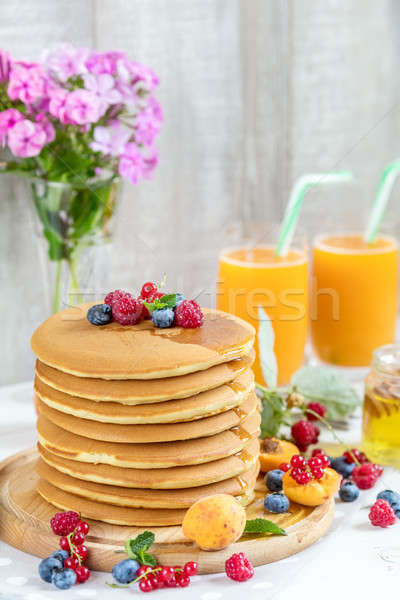 Fresh delicious pancakes with summer berries on light background Stock photo © artsvitlyna