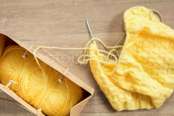Light yellow knitting wool and knitting needles on wooden backgr Stock photo © artsvitlyna