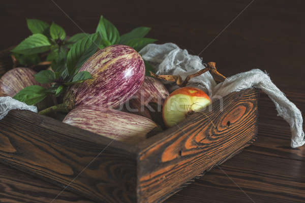 Purple graffiti eggplants, onion and green fresh basil in a wood Stock photo © artsvitlyna