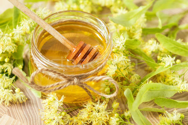 Honey in glass jars with white linden flowers Stock photo © artsvitlyna