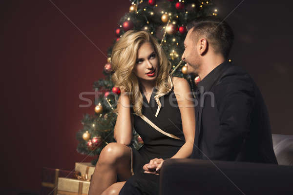Happy young people give each other gifts near the Christmas tree. Stock photo © arturkurjan